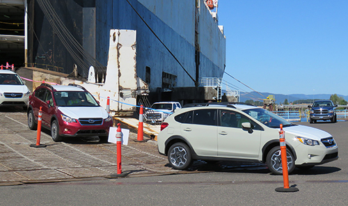 Subarus driving off ship