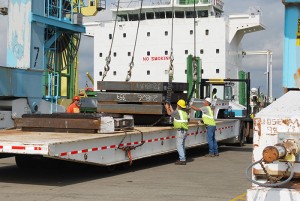 Longshore workers at the Port of Vancouver USA transfer steel slabs from ship to truck